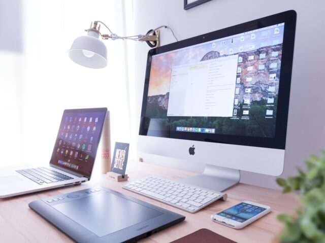 Photo by Domenico Loia silver iMac near iPhone on brown wooden table